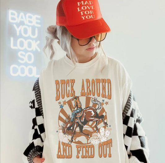 Oversized unisex fit, ivory colored t-shirt featuring a country western graphic with a bucking horse in a desert with cactus.