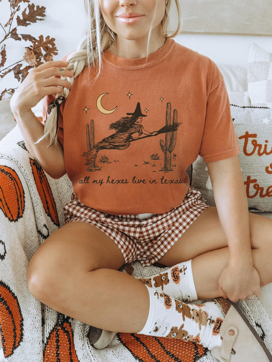 Oversized orange tshirt with a rustic image of a witch flying through the desert on her broom under the moonlit sky. Tshirt features a crewneck style neck.