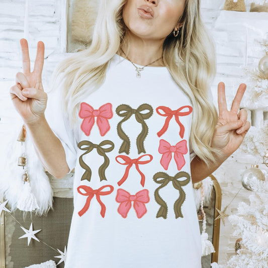 Oversized crewneck white tshirt featuring an array of pink, red and green Christmas coquette bows of different shapes and textures.