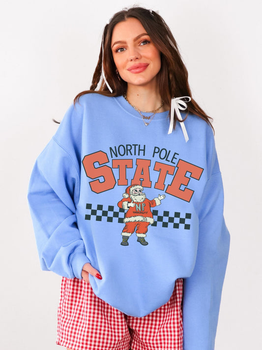 Long sleeve, oversized blue crewneck sweatshirt featuring a retro Santa with the words North Pole State