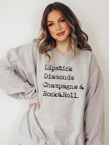 Model wearing athletic heather crewneck with distressed rock and roll, champagne, lipstick and diamonds graphic