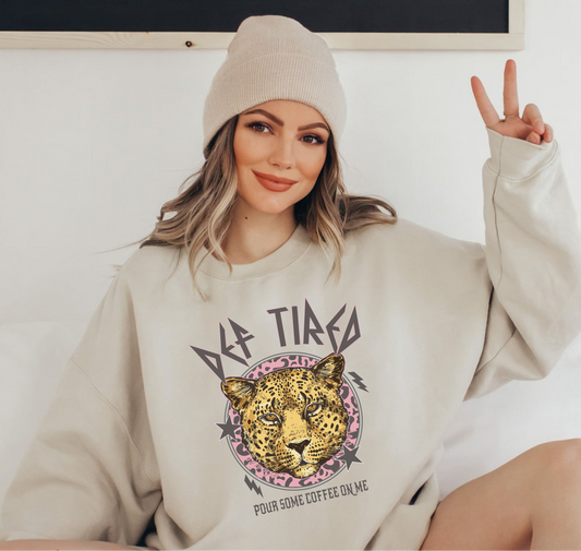 Model is wearing a sand gildan crewneck with def leppard inspired coffee graphic